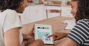 Two women looking at social media post with a dog on an iPad